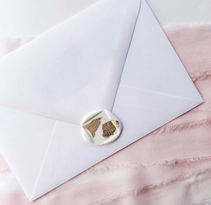 gold foil on white square wax seal on white envelope