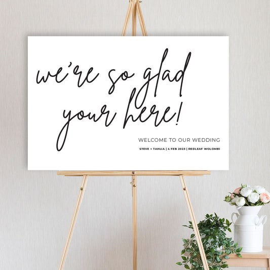 glad you're here fun modern wedding welcome sign sitting on a timber easel engagement party, birthday