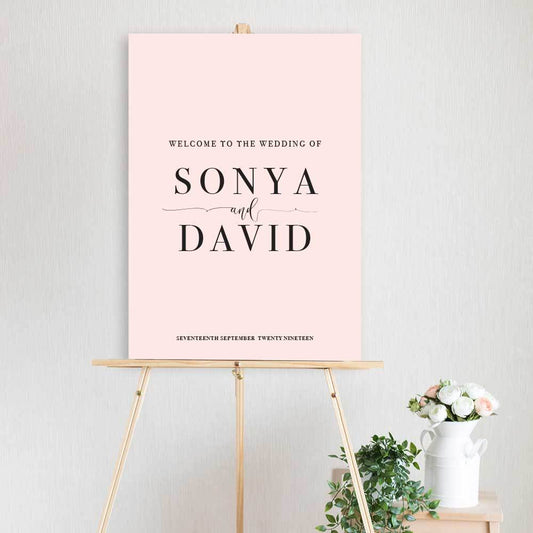 classic pink and black welcome sign for wedding, engagement or birthday party sitting on timber welcome sign